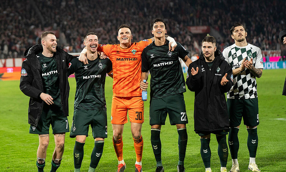 Die Spieler feiern vor der Kurve. 