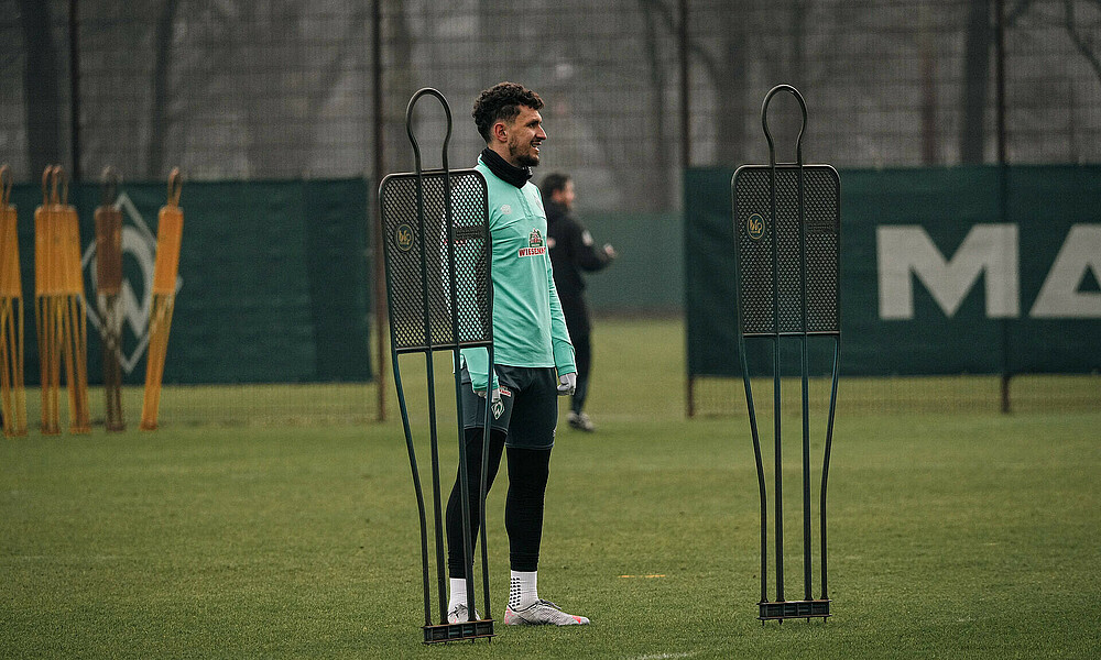 Milos Veljkovic zwischen Aufstellern auf dem Trainingsplatz. 