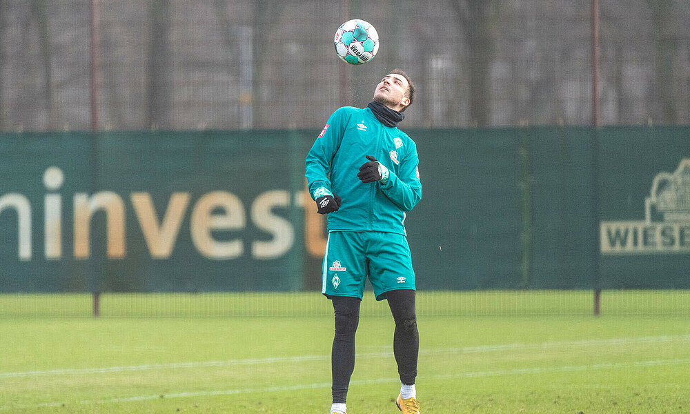 Kevin Möhwald hält den Ball im Training hoch.