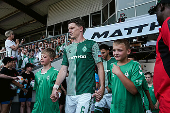 Jens Stage mit zwei Einlaufkindern an der Hand.