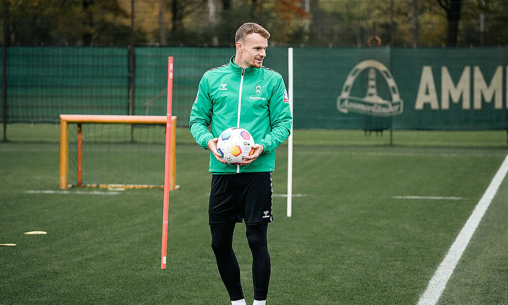 Christian Groß steht auf dem Trainingsplatz und hat einen Ball in der Hand.