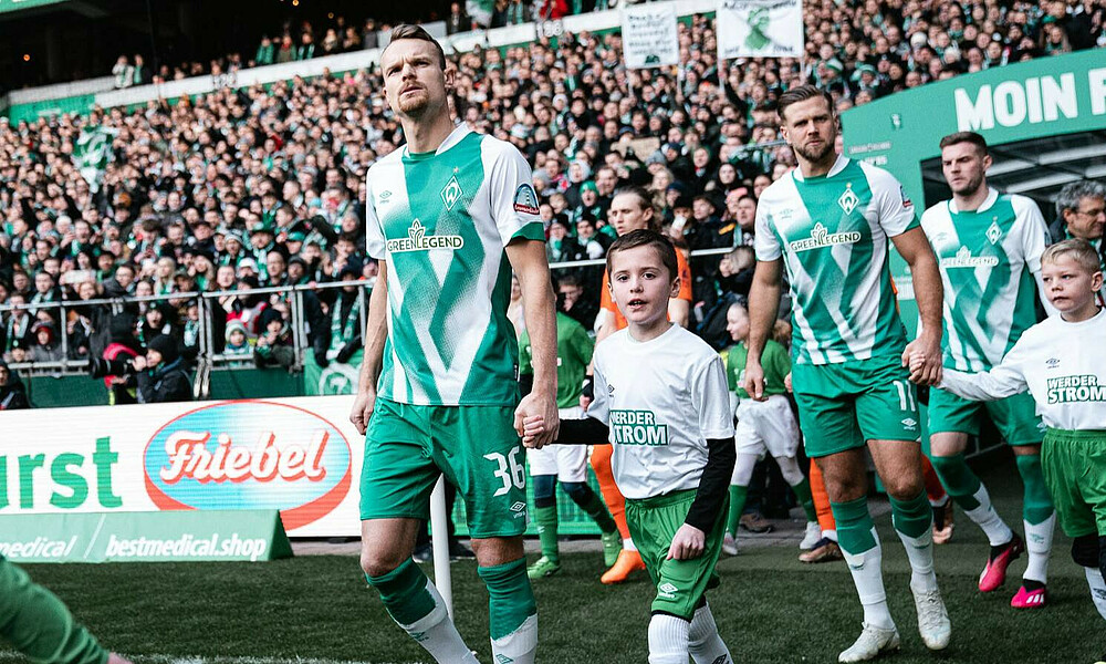 null Die Spieler laufen aus dem Spielertunnel.