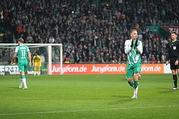 Niklas Schmidt blickt auf die Tribüne und applaudiert. 