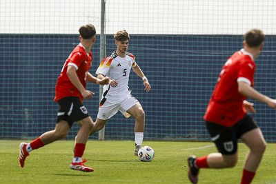 Mick Schmetgens im DFB-Trikot mit einem Ball am Fuß.