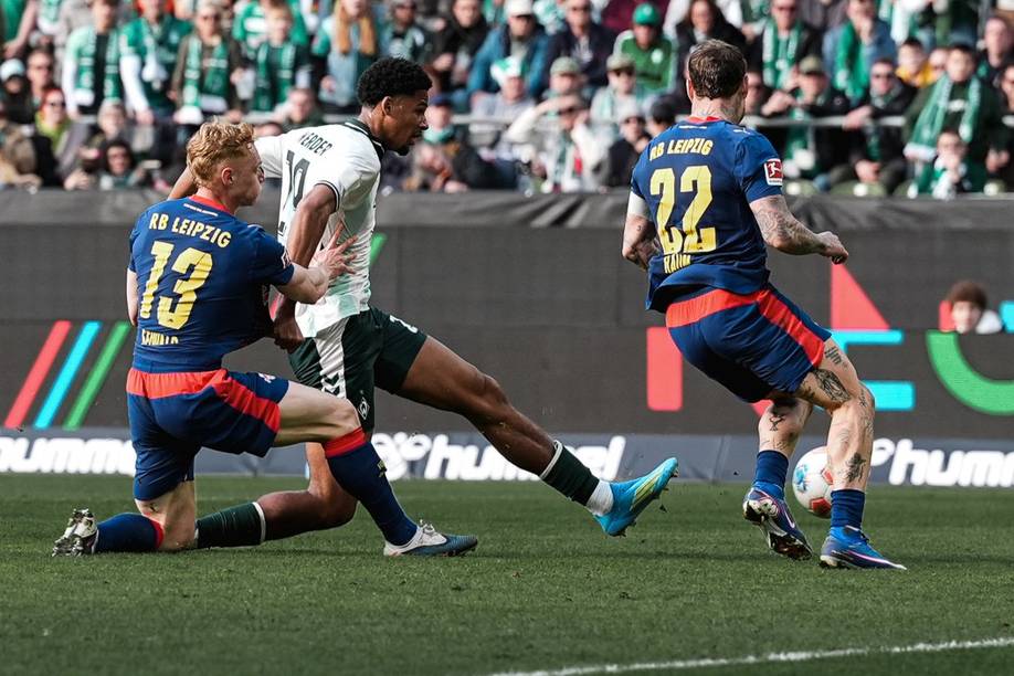 Salim Musah schießt. Es laufen links und rechts von ihm zwei Leipzig-Spieler-