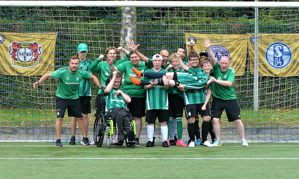 Das Handicap-Team Werder Youngstars steht vor einem Tor und jubelt.
