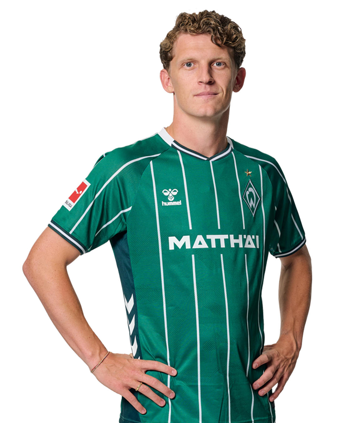 Jens Stage in einem grün-weiß gestreiften Trikot mit der Aufschrift „MATTHÄI“ auf der Vorderseite steht mit den Händen in den Hüften da und schaut nach vorne.