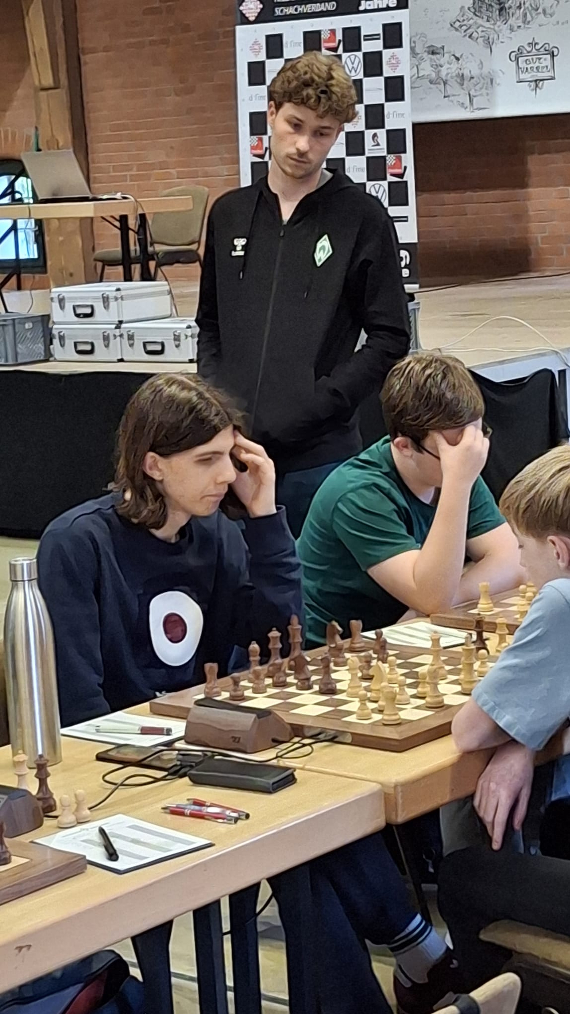 Blaues Sweatshirt: Samuel Pfeffer, im Hintergrund IM Collin Colbow und durch Hand verdeckt Henry Engelhaupt