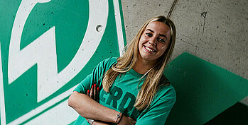 Nina Lührßen vor dem Werder-Logo.