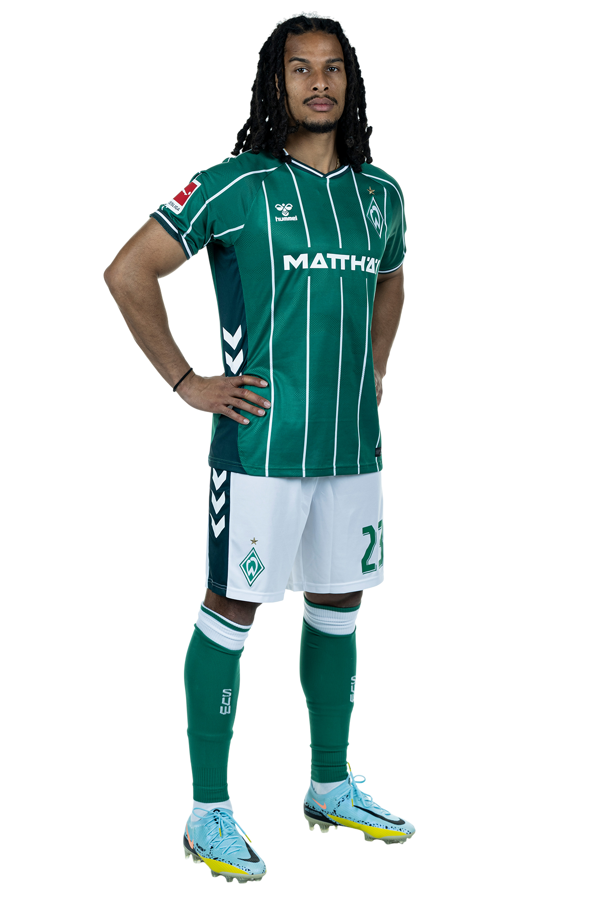 Isaac Schmidt in einem grün-weiß gestreiften Trikot mit der Aufschrift „MATTHÄI“ auf der Vorderseite steht mit den Händen in den Hüften da und schaut nach vorne.
