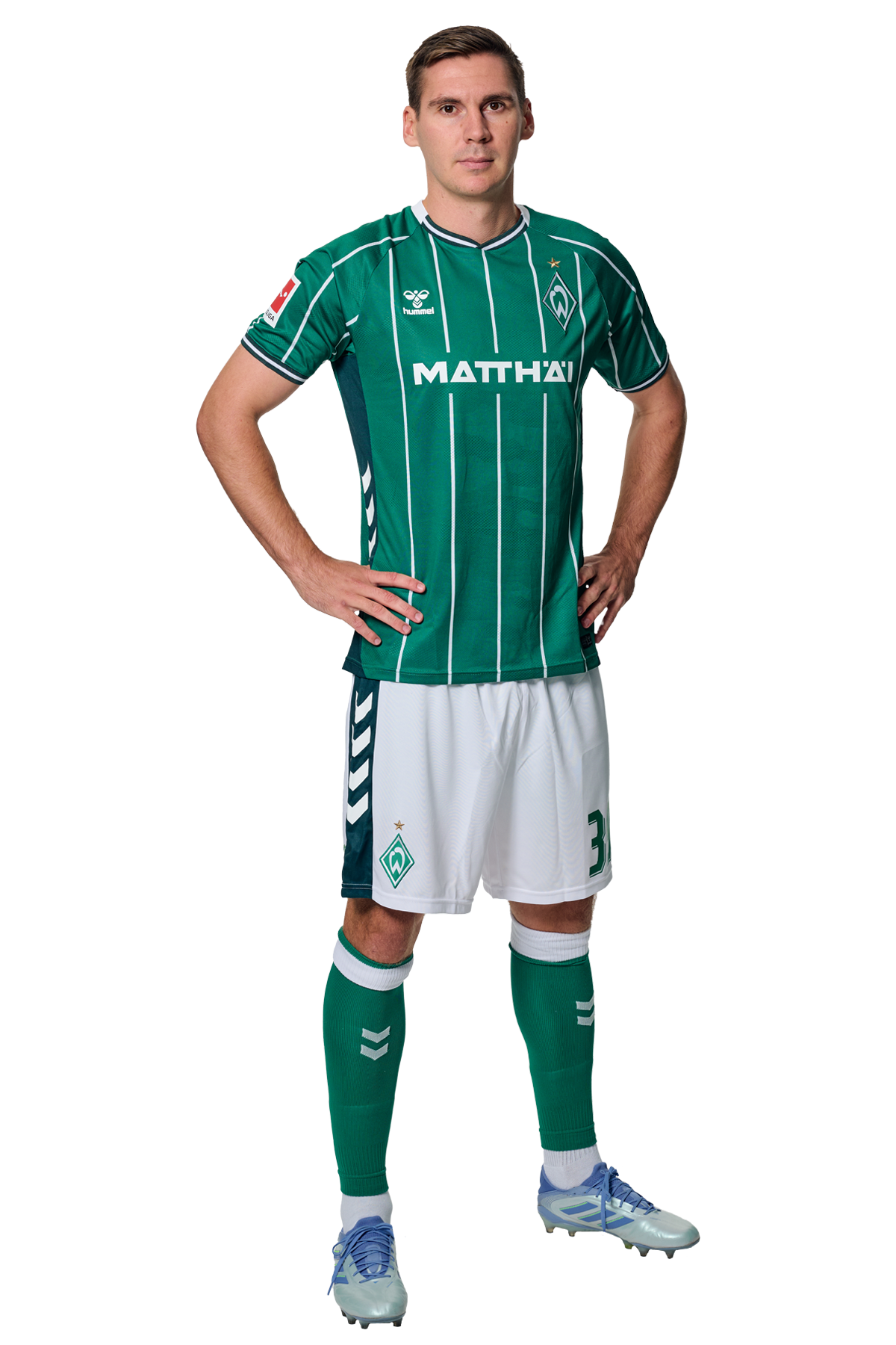 Maximilian Wöber in einem grün-weiß gestreiften Trikot mit der Aufschrift „MATTHÄI“ auf der Vorderseite steht mit den Händen in den Hüften da und schaut nach vorne.