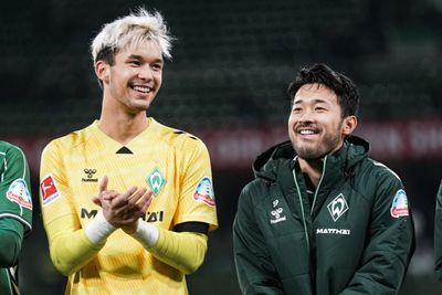 Mio Backhaus und Yukinari Sugawara stehen nebeneinander und lachen.