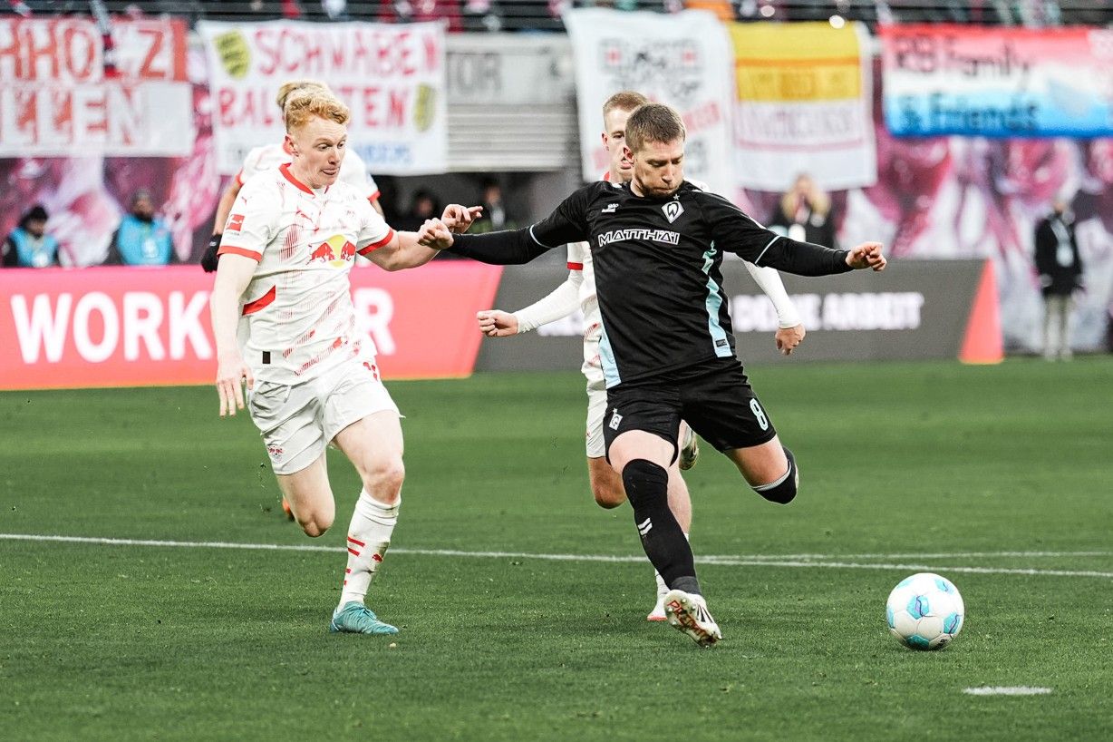 Mitchell Weiser schießt. Ein Leipziger Spieler versucht ihn zu behindern.