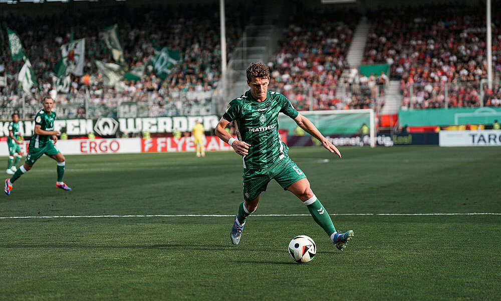 Jens Stage macht einen weiten Schritt zum Ball.