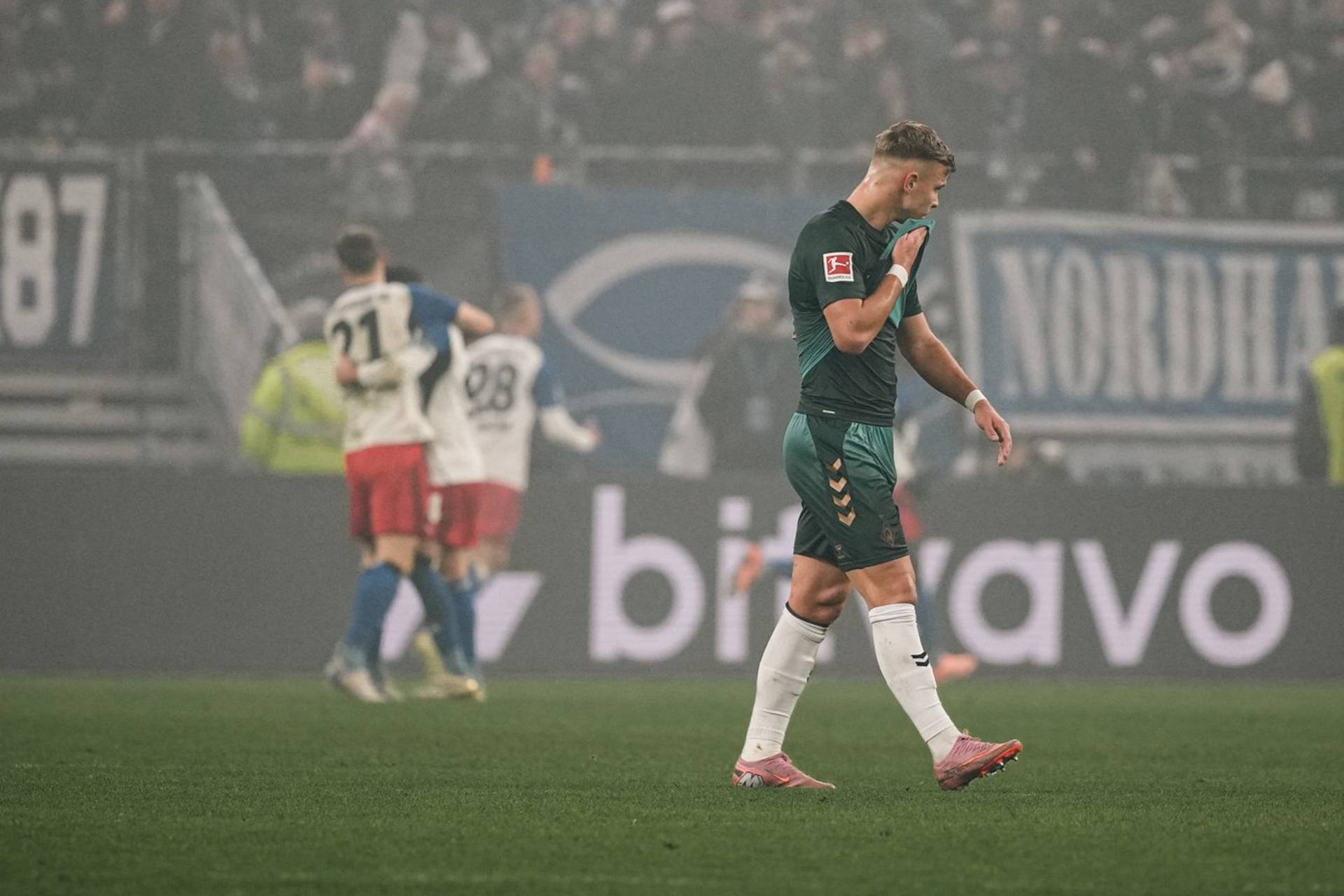 Keke Topp wischt sich mit dem Trikot durch das Gesicht.