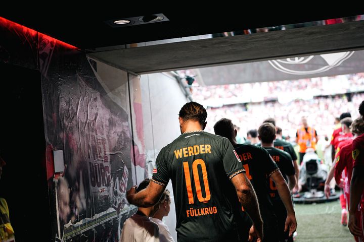 Niclas Füllkrug im Spielertunnel mit seinem Einlaufkind.