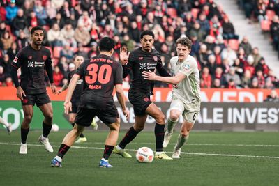 Jens Stage mit Blick auf den Ball, um ihn herum viele Leverkusener.