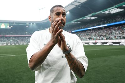 Daniel Thioune klatscht auf dem Rasen den Fans Beifall.