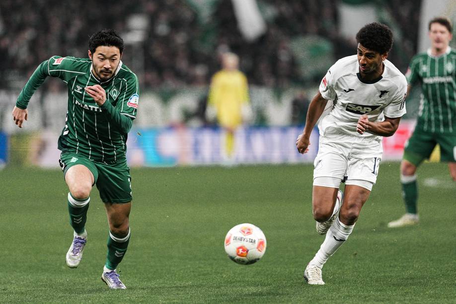 Yukinari Sugawara running next to a Hoffenheim player.
