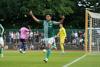 Ricardo Schwarz jubelt mit ausgestreckten Zeigefingern im grünen Trikot. 