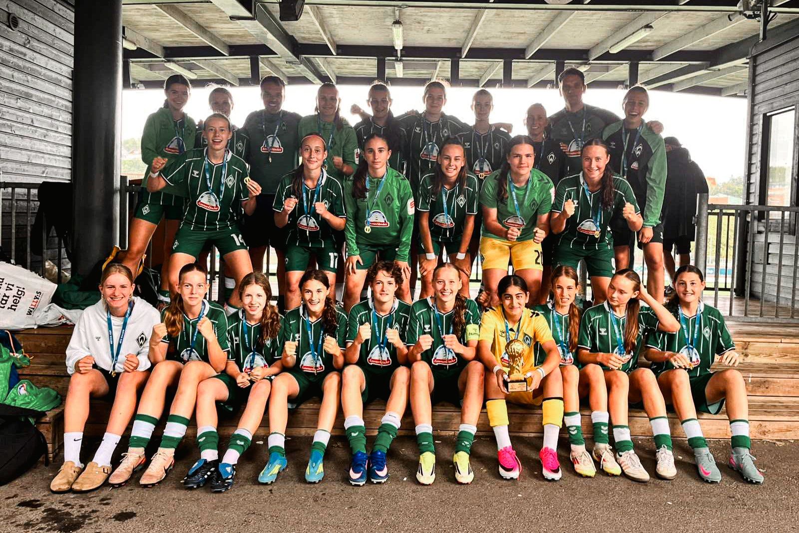 Die U17 auf einem Mannschaftsfoto mit Medaillen und Pokal.