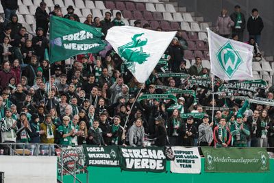Der Werder-Auswärtsblock in Essen am Stadion an der Hafenstraße mit wehenden Fahnen.