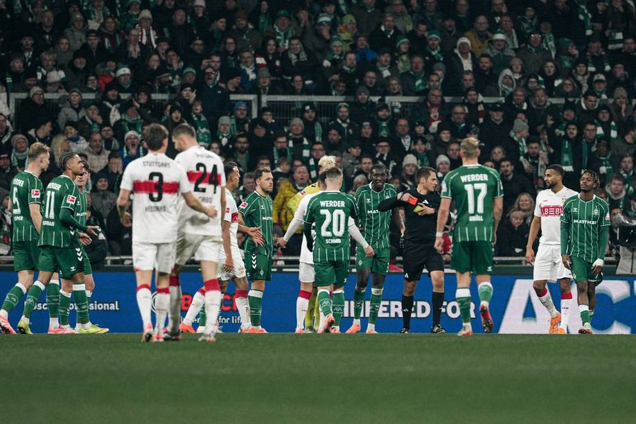 Robert Hartmann steckt sich die Karten in die Taschen, Karim Coulibaly guckt ungläubig.