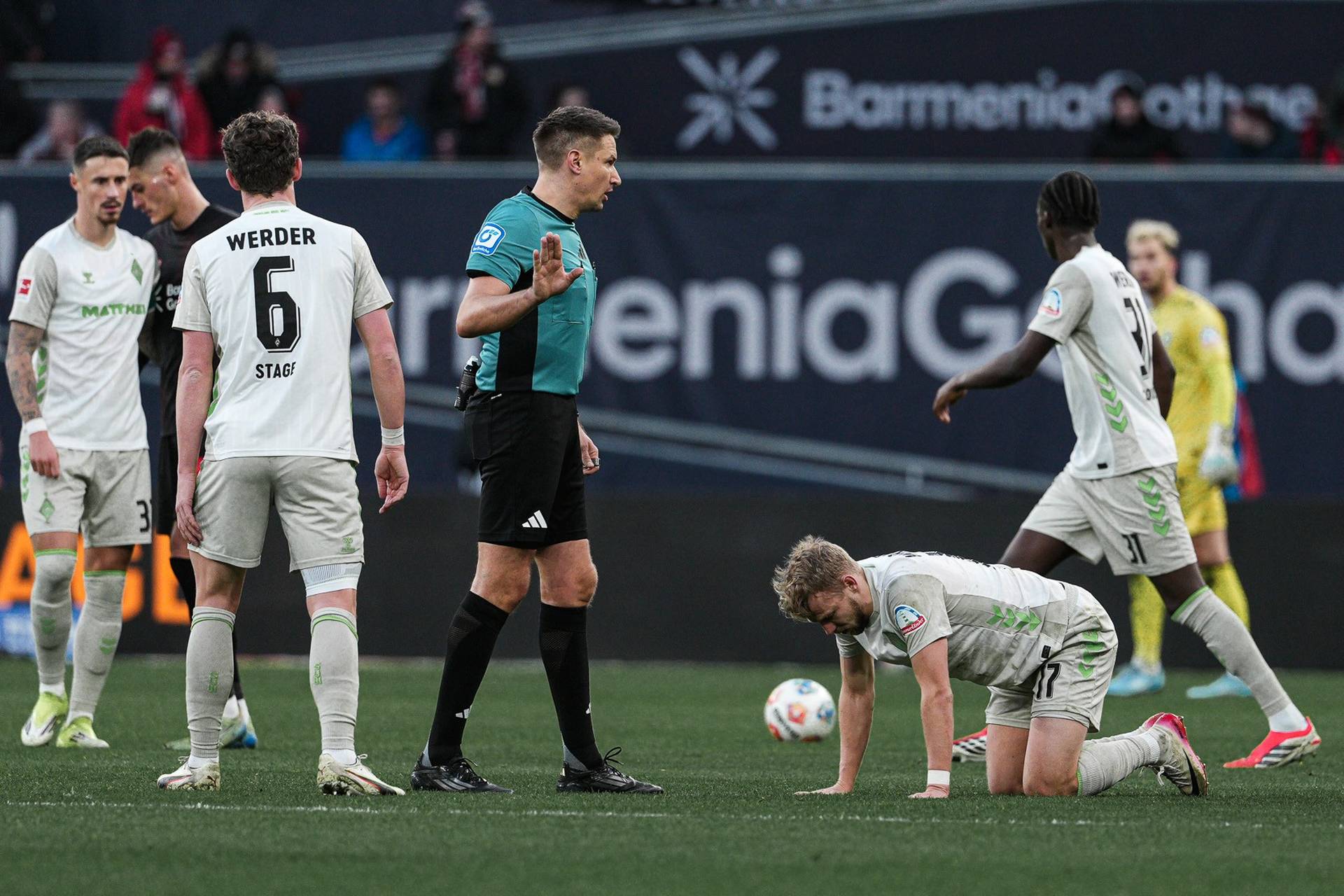 Tobias Reichel auf dem Platz, um ihn herum Werder-Spieler.