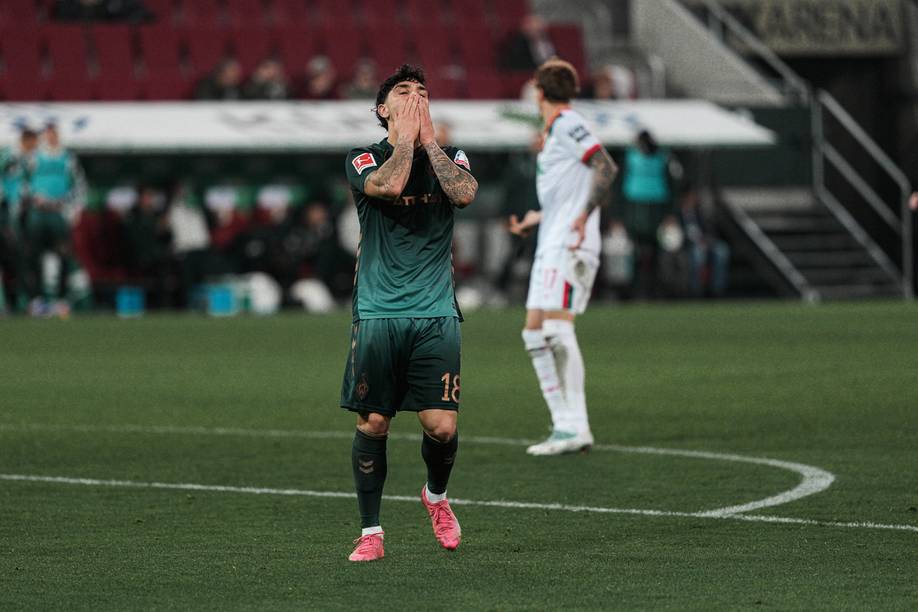 Cameros Puertas begräbt sein Gesicht in seinen Händen, er steht auf dem Platz in Augsburg.