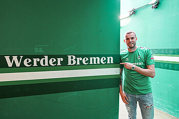 Marvin Ducksch lehnt an einer Wand mit der Aufschrift 