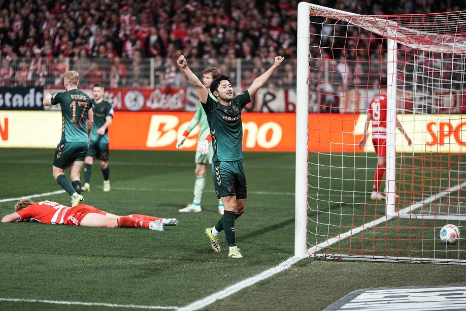 Yukinari Sugawara jubelt im Spiel gegen Union Berlin in Richtung des Gästeblocks.