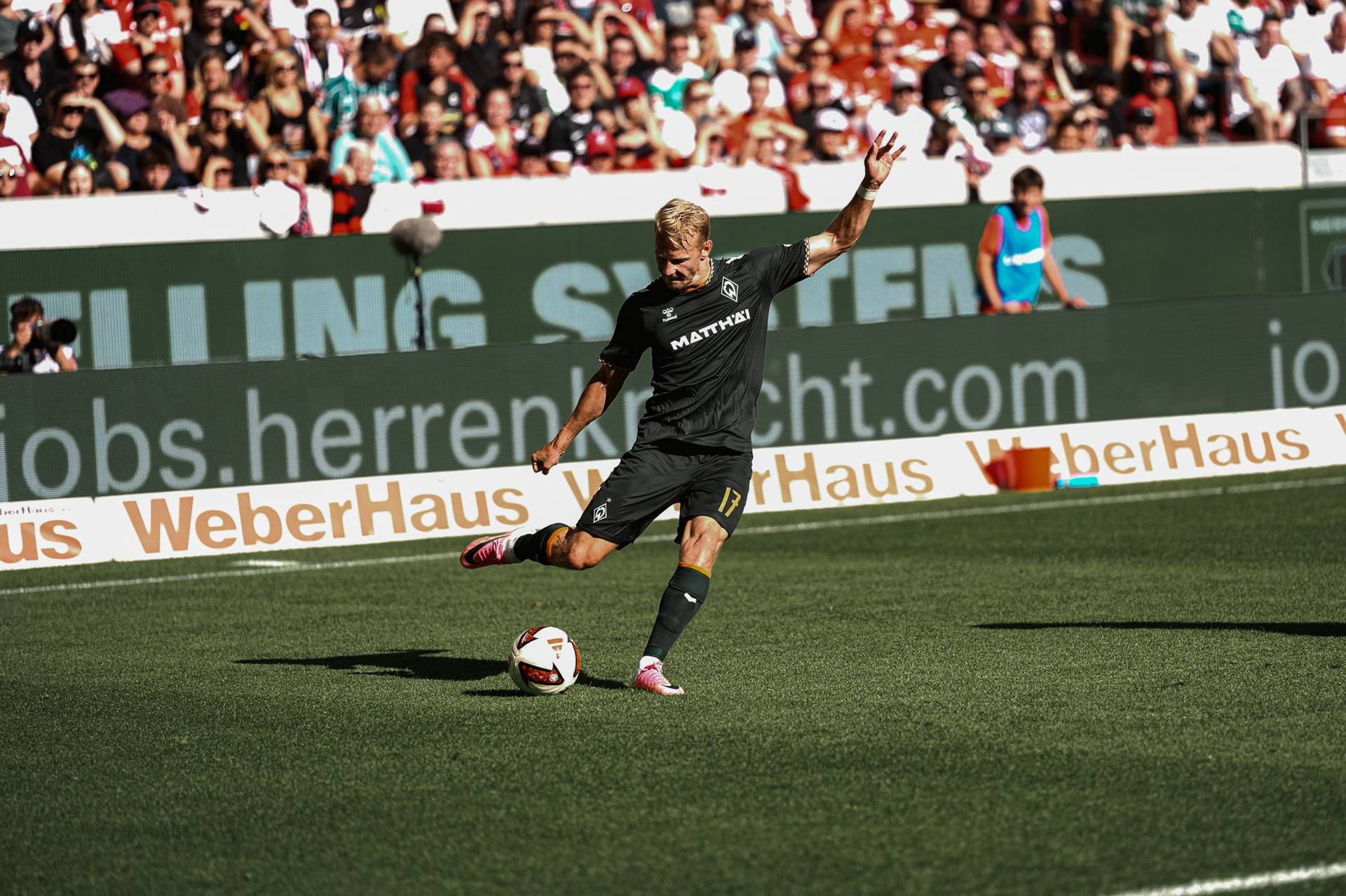Marco Grüll schlägt im Spiel gegen den SC Freiburg eine Flanke.
