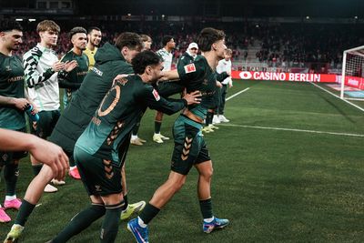 Patrice Čović im grünen Trikot wird von seinen Kollegen auf dem Rasen nach vorne geschubst.