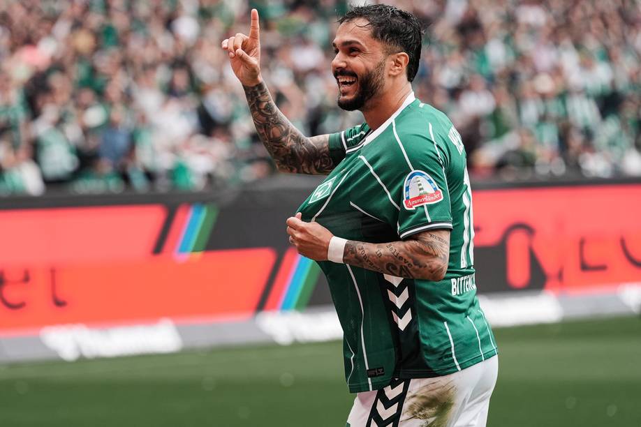 Leo Bittencourt jubelt mit dem Zeigefinger gestreckt, lacht und zeigt die Werder-Raute.