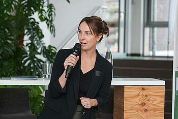 Anne-Kathrin Laufmann spricht in Mikrofon und gestikuliert dabei mit ihrer Hand.