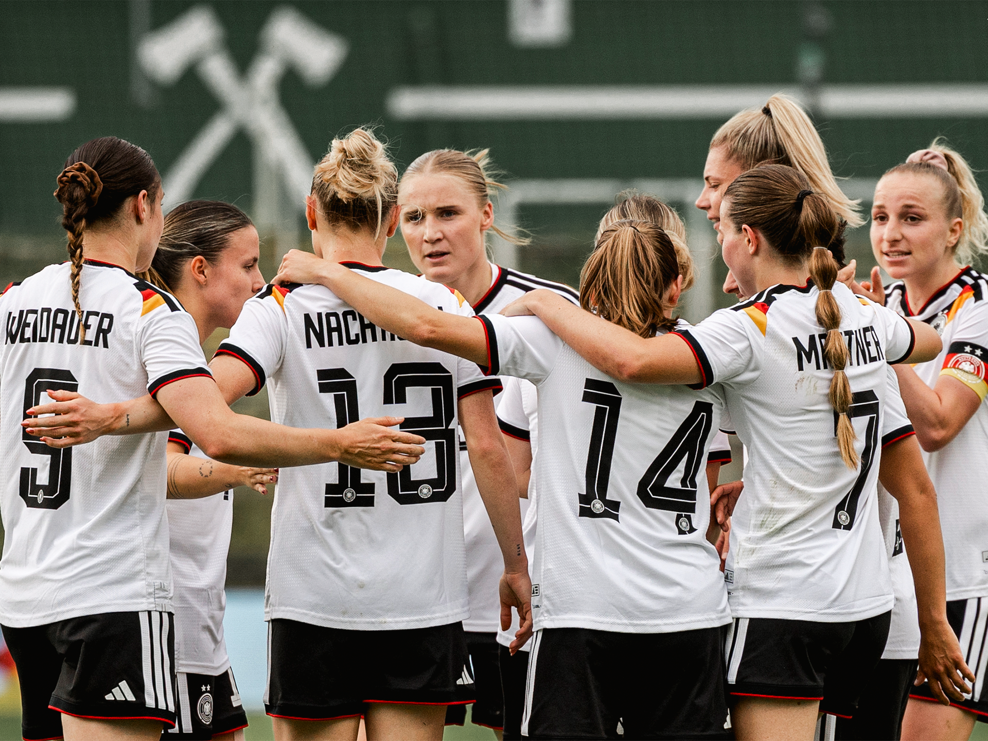 Die U23-Frauen-Nationalmannschaft bildet einen Jubelkreis auf dem feld.