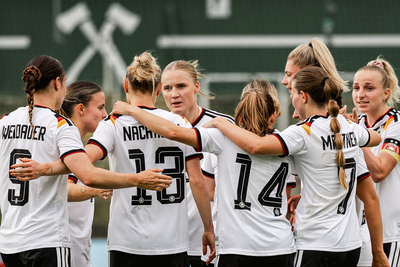 Die U23-Frauen-Nationalmannschaft bildet einen Jubelkreis auf dem feld.