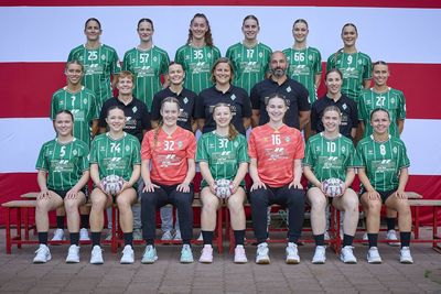 Eine Handball-Mannschaft, die zum Mannschaftsfoto zusammensteht. Im Hintergrund ist die Bremer Flagge zusehen.