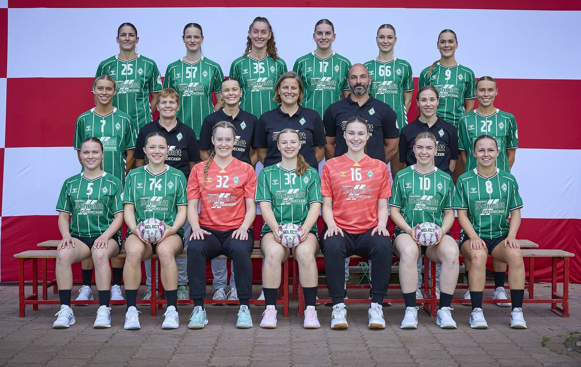 Eine Handball-Mannschaft, die zum Mannschaftsfoto zusammensteht. Im Hintergrund ist die Bremer Flagge zusehen.