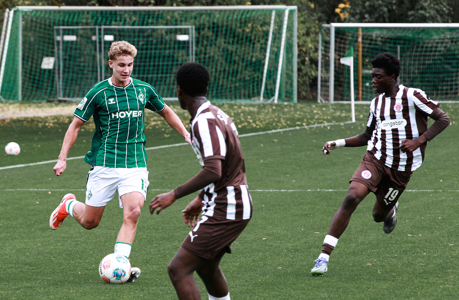 Ein U17-Spieler von Werder dribbelt. Ein Spieler von St. Pauli ist dabei.