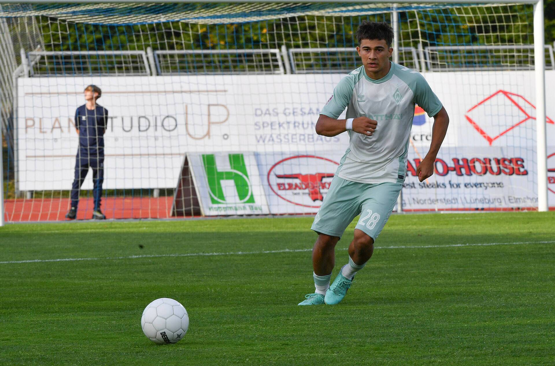 Ethan Kohler guckt zum Ball im Werder-Auswärtstrikot 24/25
