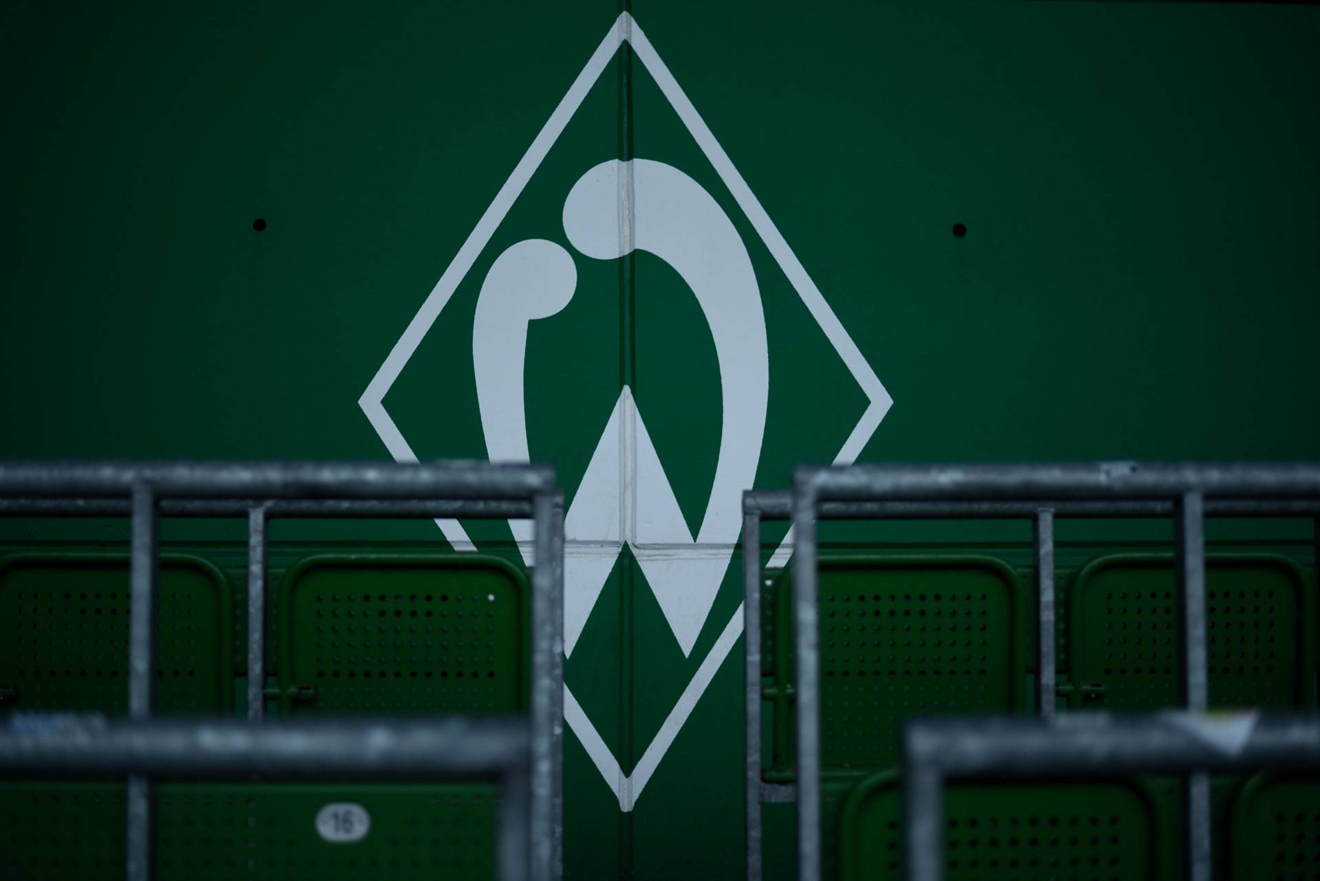 Eine Werder-Raute an einer Wand. Davor sind Rohre der Stehplätze.