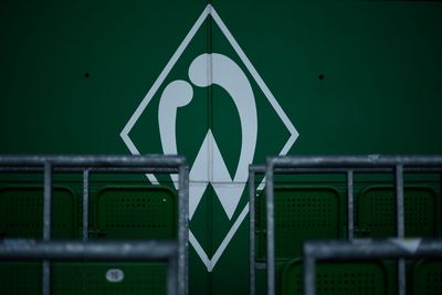 Eine Werder-Raute an einer Wand. Davor sind Rohre der Stehplätze.