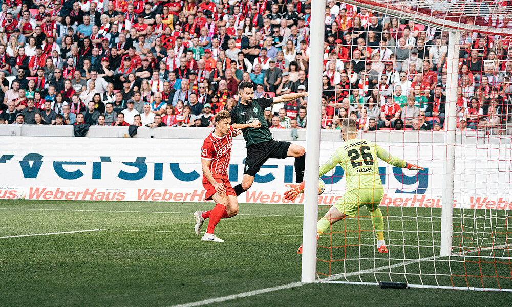 null Anthony Jung schießt den Ball im Zweikampf gegen einen Freiburger Spieler auf das Tor von Mark Flekken.