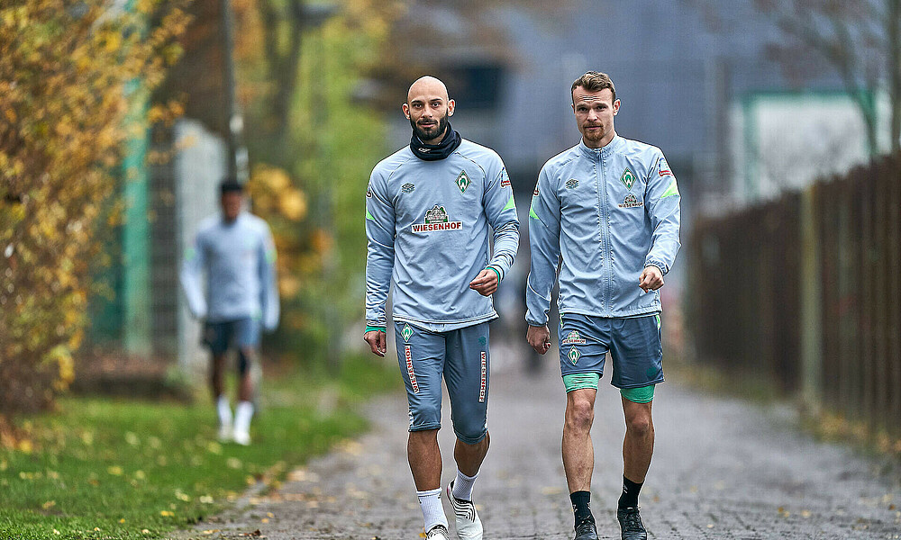 null Werder-Spieler Ömer Toprak und Christian Groß auf dem Weg zum Training.