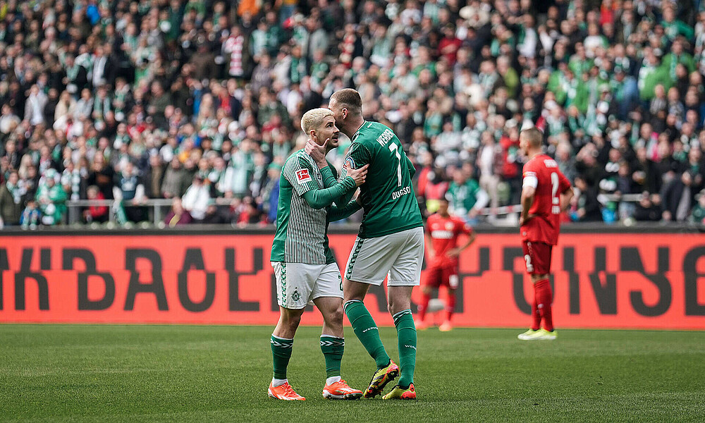 Ducksch und Schmid umarmen sich auf dem Feld.