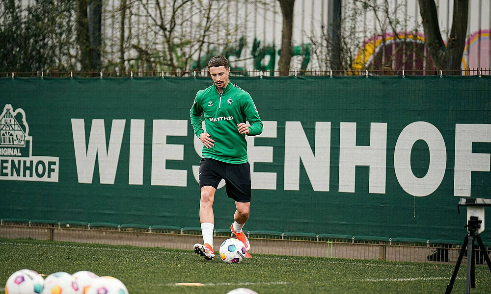 Marco Friedl auf dem Trainingsplatz. er passt einen Ball.