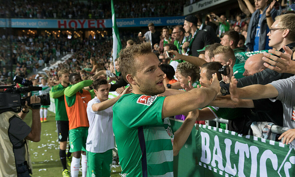 null Lennart Thy klatscht mit Fans in der Ostkurve ab.