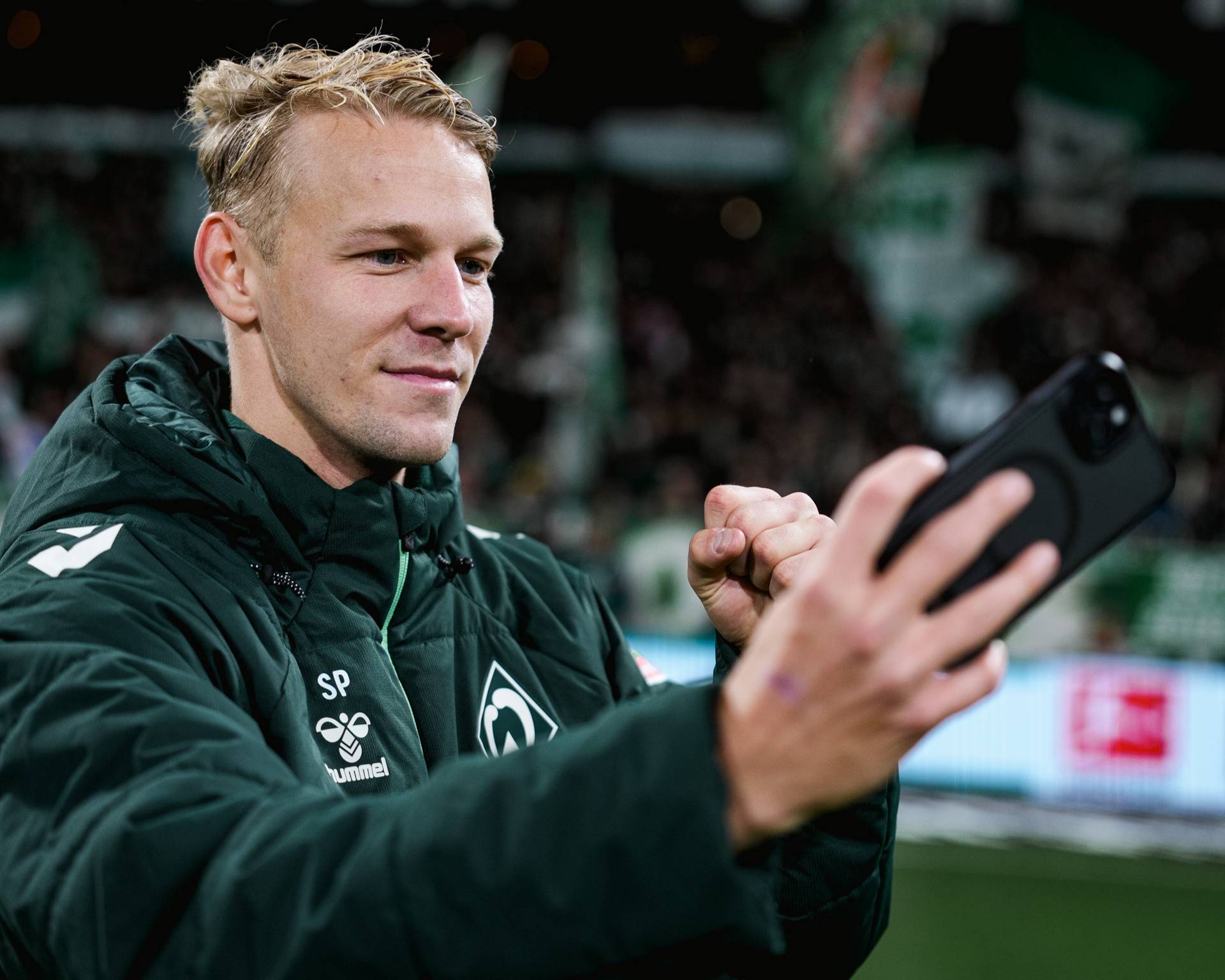 Grüll macht ein Selfie vor der Ostkurve