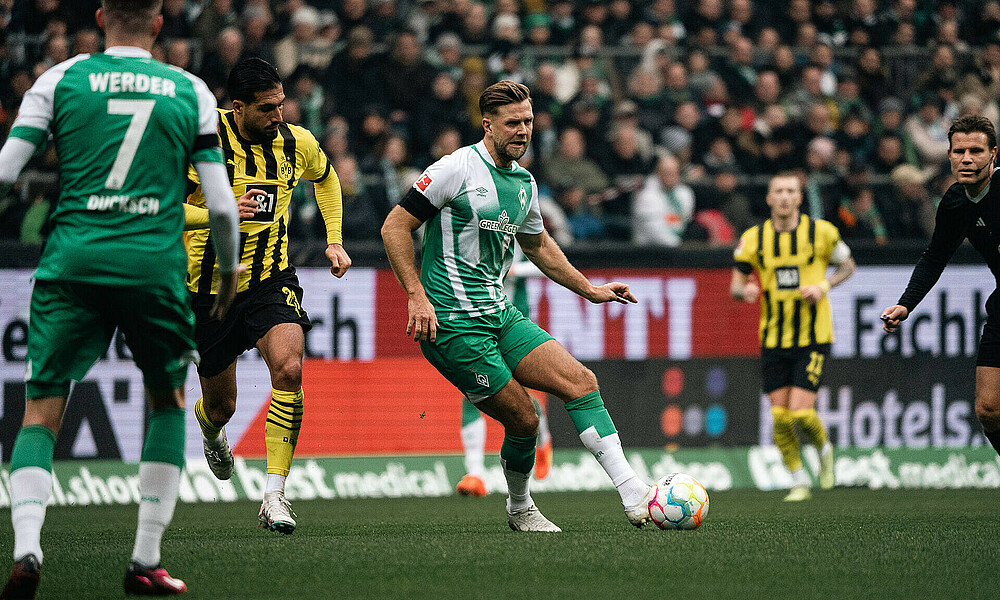 Niclas Füllkrug mit dem Ball am Fuß vor Dortmunds Emre Can. 